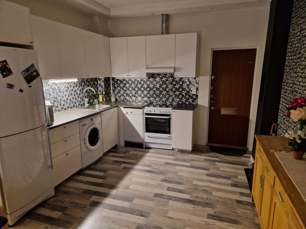 Kök med vita luckor och mosaikkakel